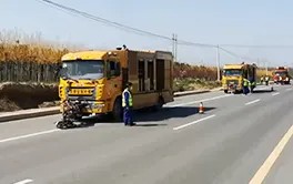 Professional road marking removal truck operating on asphalt pavement with precision control