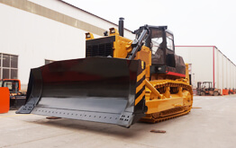 Powerful track dozer leveling site for industrial construction