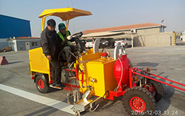 Driving-type thermoplastic road marker in operation on a construction site